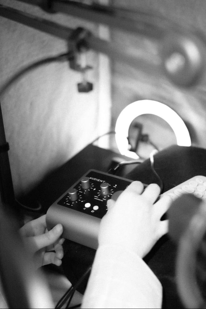 Чорно-білий кадр: руки на аудіоінтерфейсі Audient